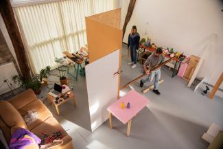 Two persons walking around in a mobile room with spatial structures.