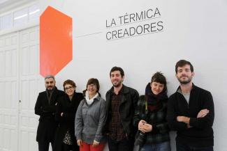 A group of people posing together in front of a white and orange advertisement.