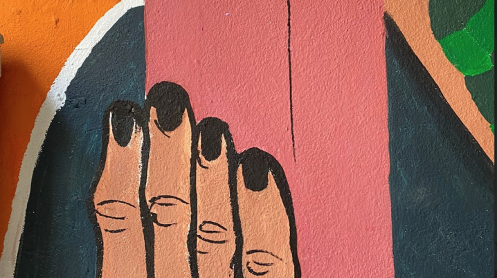 detail of a wall painting by Espace Fxmme - Talk to the Walls, of a person holding a brick in their hand, at Globe Aroma, Brussels