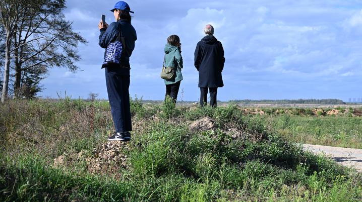 three people standing in a natural lanscapes with grass and trees