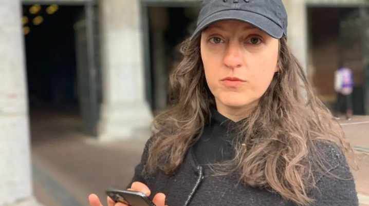 woman with cap and mobile phone in hand