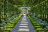 A garden arch which a lush set of plants use to support themselves