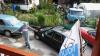 A man standing in between two cars photographed from a balcony.