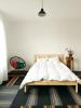 A bed and a chair in a carpeted room.