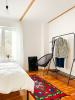A bed, carpet and clothing rack in a room.